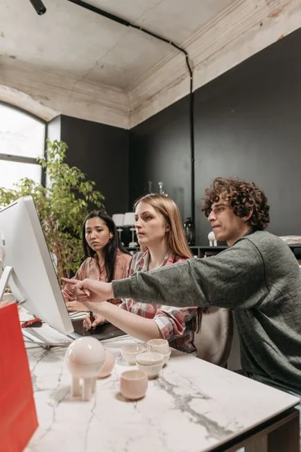 Un photographe dans un environnement créatif avec un ordinateur portable et une tablette Wacom, concentré sur la retouche de photos en intérieur.